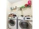 Functional laundry room featuring side-by-side washer and dryer with wire shelving above at 6834 Fireside Ln, South Fulton, GA 30349