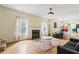 Bright living room with fireplace, hardwood floors, and open floor plan that seamlessly flows into the kitchen at 6834 Fireside Ln, South Fulton, GA 30349