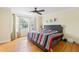 Relaxing main bedroom featuring hardwood floors, a ceiling fan, and bay window overlooking the front yard at 6834 Fireside Ln, South Fulton, GA 30349