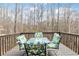 A patio set with chairs and table sits on the deck overlooking the wooded area at 6834 Fireside Ln, South Fulton, GA 30349