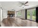 Spacious living room featuring a stone fireplace, built-in shelving, hardwood floors, and outdoor access at 855 Riverbend Sw Dr, Lilburn, GA 30047