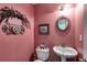 Charming half bathroom with pedestal sink and decorative wall accents at 144 Bobs Sw Dr, Mableton, GA 30126