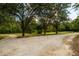 Long gravel driveway leading to a charming house with mature trees at 3241 Briscoe Rd, Loganville, GA 30052