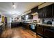 Modern kitchen with dark wood cabinetry, stainless steel appliances, and granite countertops at 3241 Briscoe Rd, Loganville, GA 30052