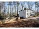 White brick house with black windows, a wooden fence, and a sloped yard at 7715 Ryefield Dr, Sandy Springs, GA 30350