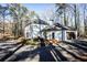 White brick house with black garage door and windows, surrounded by trees at 7715 Ryefield Dr, Sandy Springs, GA 30350