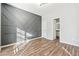 Bedroom with hardwood floors, accent wall, and access to bathroom at 3736 Busker Mill Ln, Ellenwood, GA 30294
