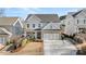 Two-story home with gray siding, brick accents, and a three-car garage at 91 Harris St, Buford, GA 30518