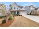 Two-story home with gray siding, brick accents, and a three-car garage at 91 Harris St, Buford, GA 30518