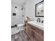 Basement bathroom with subway tile shower, wood vanity, and grey tile floor at 2770 Blake Towers Ln, Buford, GA 30519