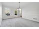 Bright dining room with gray carpet, chandelier, and large windows at 3182 Henderson Walk, Atlanta, GA 30340