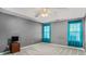 Spacious bedroom with ceiling fan, gray walls, and teal curtains at 45 Kendall Ln, Covington, GA 30014