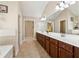 Double vanity bathroom with large mirror and neutral tile at 4705 Sanderling St, Cumming, GA 30041