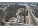 An aerial view shows modern townhomes with a winding access road, near a bustling highway and lush green spaces at 747 Trevett Way, Marietta, GA 30062