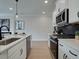 Modern kitchen with white cabinets, stainless steel appliances, and dark tile backsplash at 747 Trevett Way, Marietta, GA 30062