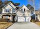 Two-story house with beige siding, brick accents, and a two-car garage at 1715 Crestwell Ln, Grayson, GA 30017