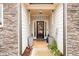 Charming front entry with stone accents, leading to a dark wood front door with wreath and decorative accents at 3430 Summerpoint Xing, Cumming, GA 30028