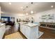Open-concept kitchen with island seating flows into dining and living spaces, perfect for entertaining at 3430 Summerpoint Xing, Cumming, GA 30028
