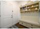 Bright mudroom features a built-in bench, storage cabinets, shelving and coat hooks for organization and style at 3430 Summerpoint Xing, Cumming, GA 30028