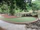 Landscaped putting green with brick border near a pond at 1356 Lucan Ln # Wc226, Lawrenceville, GA 30043