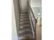 Carpeted staircase with modern black iron and wood railing, leading to the upper level of the home at 1356 Lucan Ln # Wc226, Lawrenceville, GA 30043