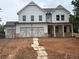 Charming two-story home with white siding, large windows, a two-car garage, and an inviting front porch at 344 Riverwood Pass, Dallas, GA 30157