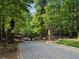 Ornate wooden gate leading into a community with a paved driveway at 4844 Elkhorn Hill Dr, Suwanee, GA 30024