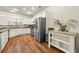 Well-lit kitchen featuring stainless steel appliances, white cabinetry, and beautiful hardwood floors at 1503 Dolcetto Nw Trce # 2, Kennesaw, GA 30152