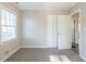 Well-lit bedroom with neutral walls and carpet, featuring a window, closet, and access to hallway at 2833 Lynda Pl, Decatur, GA 30032