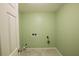 Simple laundry room with light green walls and tile flooring at 4617 Dunover Cir, Dunwoody, GA 30360