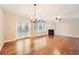 Open concept living and dining area with hardwood floors, fireplace, and chandelier at 1600 Watercress Se Ct, Mableton, GA 30126