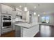 Open concept kitchen with gray cabinets, granite countertops, and stainless steel appliances at 2798 Turnwater St, Hoschton, GA 30548