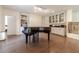 Spacious basement recreation room with hardwood floors, fireplace, built-in shelving, and grand piano at 5960 Overlook Club Cir, Suwanee, GA 30024