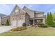 Two-story home with stone and shingle accents, two-car garage, and landscaped front yard at 5960 Overlook Club Cir, Suwanee, GA 30024