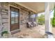 Stone porch with two wicker chairs and a view of the backyard at 5960 Overlook Club Cir, Suwanee, GA 30024