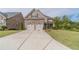 Two-story house with stone and shingle exterior, two-car garage, and landscaped yard at 5960 Overlook Club Cir, Suwanee, GA 30024