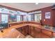 L-shaped basement bar with wood cabinets and sink at 9970 Groomsbridge Rd, Johns Creek, GA 30022