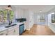 Modern kitchen with white cabinets, stainless steel appliances, and light hardwood floors at 1963 Tripp Rd, Woodstock, GA 30188