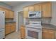 White appliances and light wood cabinets are featured in this kitchen at 2500 Rosehill Cir, Lithia Springs, GA 30122