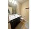 A well-lit bathroom with a single vanity, a large mirror, and a shower with glass doors at 3280 Hallmark Ln, Buford, GA 30519