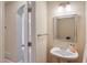 Small powder room with pedestal sink, mirror, and access to another room at 1506 Lavista Proper Cir, Decatur, GA 30033