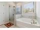 Spa-like bathroom featuring a soaking tub and a separate glass shower at 2131 Landsburg Way, Lawrenceville, GA 30043