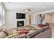 Cozy living room with fireplace, stairs, a ceiling fan, and a comfortable sectional sofa at 2131 Landsburg Way, Lawrenceville, GA 30043