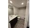 The bathroom features modern cabinetry, fixtures, and plank flooring with a tub and shower combination at 1346 Lucan Ln # Wc227, Lawrenceville, GA 30043
