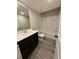 The bathroom features modern cabinetry, fixtures, and plank flooring with a tub and shower combination at 1346 Lucan Ln # Wc227, Lawrenceville, GA 30043