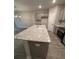 Open kitchen featuring gray cabinets, stainless appliances, granite counters, and a center island with breakfast bar at 1346 Lucan Ln # Wc227, Lawrenceville, GA 30043