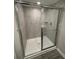 Shower features tiled walls, a glass door, and a chrome shower head at 1346 Lucan Ln # Wc227, Lawrenceville, GA 30043