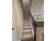 Carpeted staircase with dark wood railing leading to the upper level of the home at 1346 Lucan Ln # Wc227, Lawrenceville, GA 30043