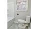 Bathroom featuring a white toilet, a white bathtub and a window at 3421 Fawn Trl, Marietta, GA 30066