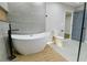 Bright bathroom showcasing a contemporary soaking tub, toilet, and gray tiled flooring, next to a door to another room at 3421 Fawn Trl, Marietta, GA 30066